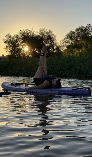 Postura de yoga sobre la tabla con el sol detrás